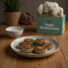 Plate of Lion's Mane "crab cakes" on a wooden table with ShroomBag in the background