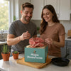 Man and woman in a kitchen picking pink oyster mushrooms from a ShroomBag